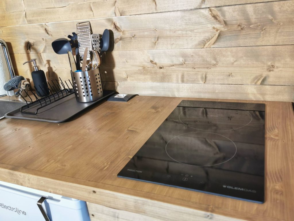 cucina con top in legno, fornelli ad induzione e utensili